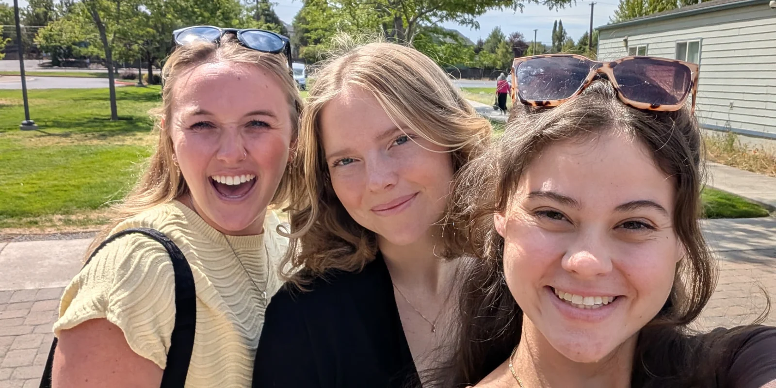 Three Trinity young adults laughing together outdoors
