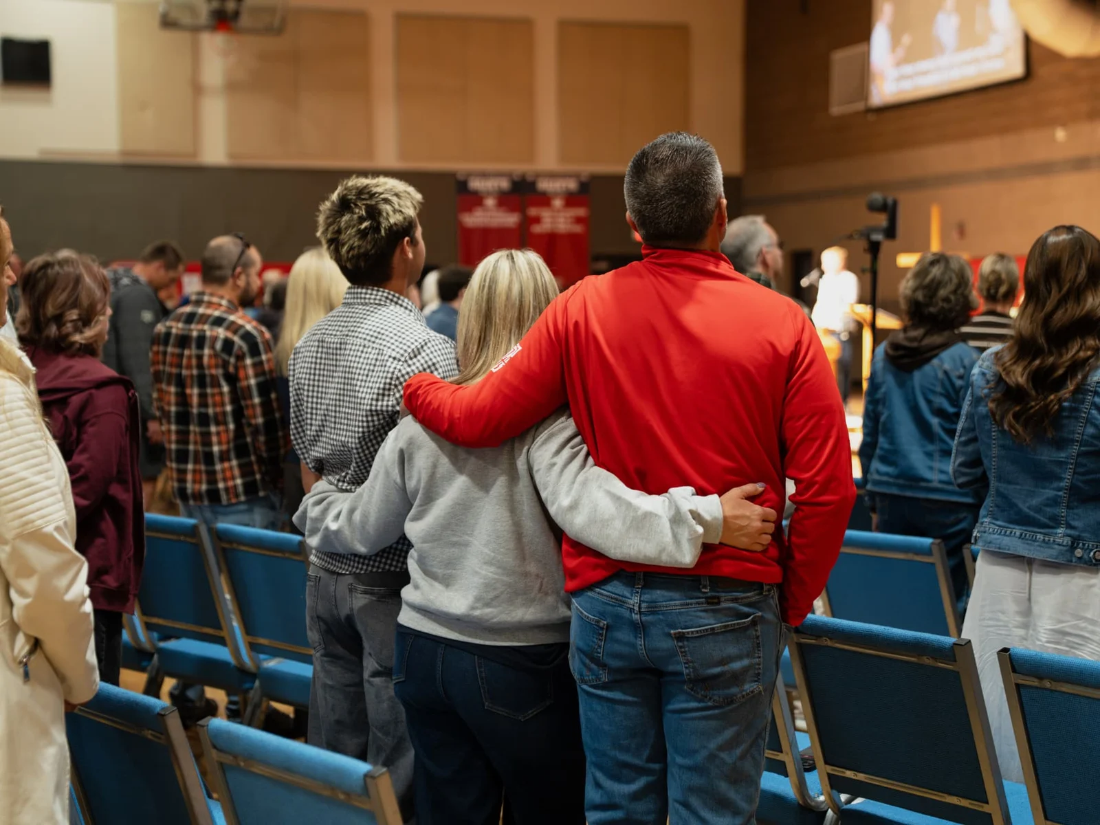 Trinity families standing together for worship at a Trinity kickoff gathering