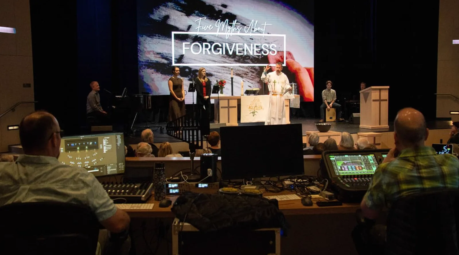 Two volunteers run sound and slides from the tech booth during a Sunday service at Trinity