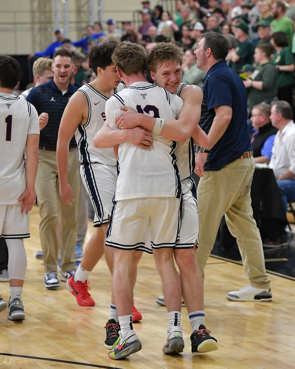 Saints basketball teammates embracing after a game